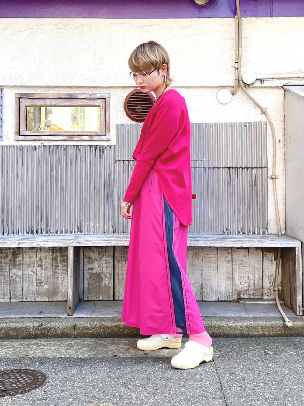 ピンク系のスカート、パープル系のスウェット、ホワイト系のシューズを着用したレディースの秋コーディネートの1枚目の写真