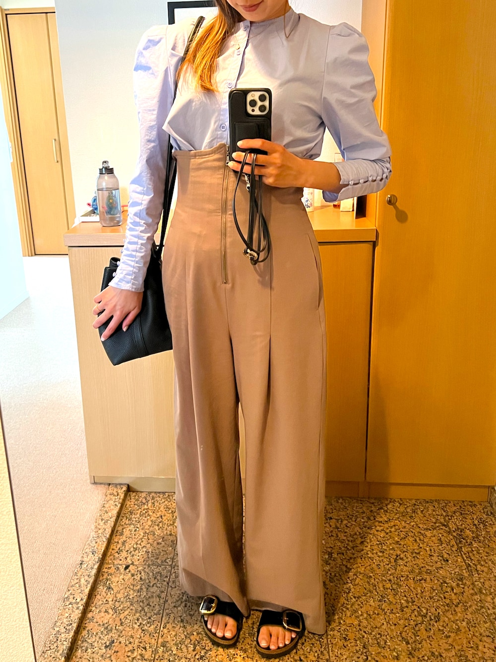 ブルー系のトップス、ベージュ系のパンツ、ブラック系のシューズを着用したレディースの夏コーディネートの1枚目の写真