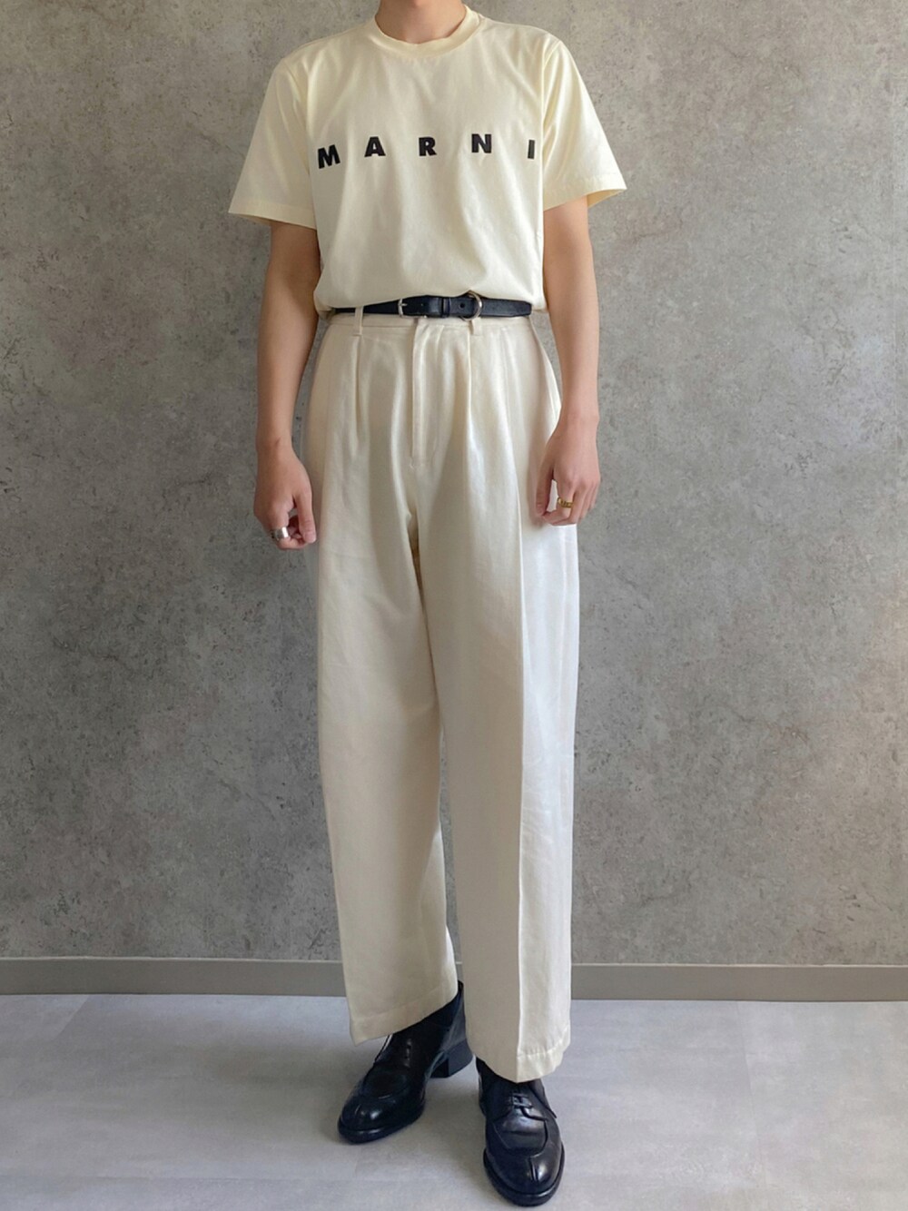 ホワイト系のTシャツ/カットソー、ホワイト系のスラックス、ブラック系のドレスシューズを着用したメンズの夏コーディネートの1枚目の写真