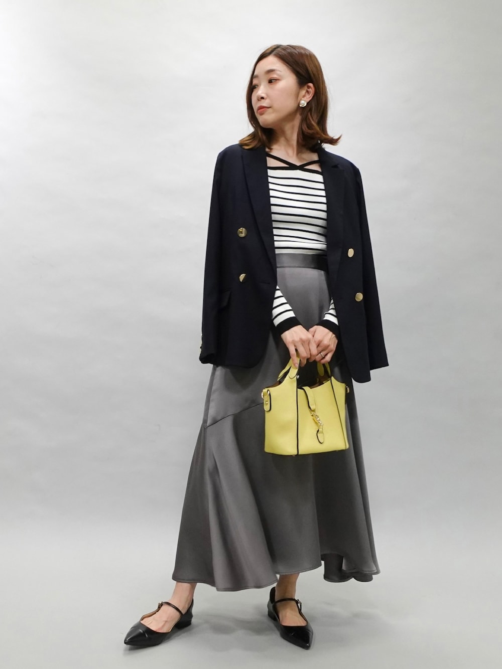 ブルー系のテーラードジャケット、その他のニット/セーター、グレー系のスカートを着用したレディースの春コーディネートの1枚目の写真