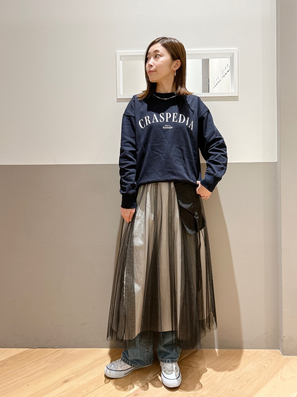 ブルー系のスウェット、ブラック系のスカート、ブルー系のデニムパンツを着用したレディースの冬コーディネートの1枚目の写真