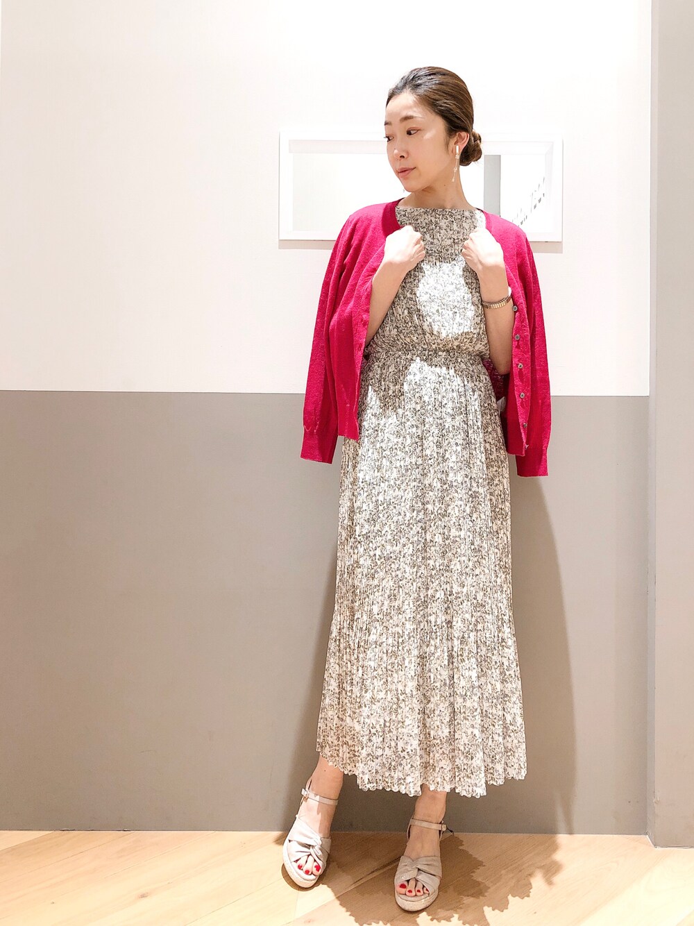 ホワイト系のワンピース、ピンク系のカーディガン/ボレロ、ゴールド系のイヤリングを着用したレディースの春コーディネートの1枚目の写真