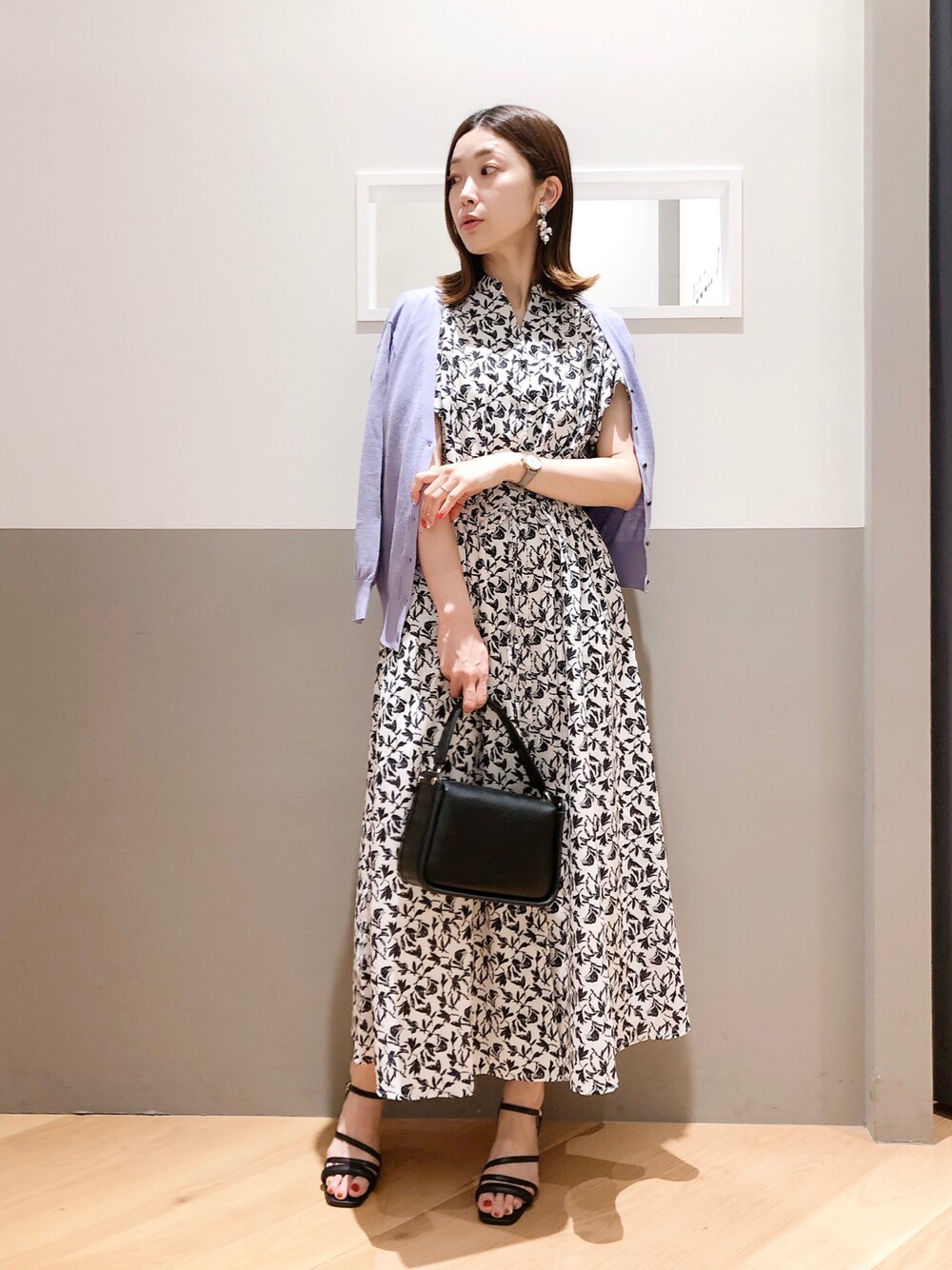 ブラック系のワンピース、パープル系のカーディガン/ボレロ、ブラック系のサンダルを着用したレディースの夏コーディネートの1枚目の写真
