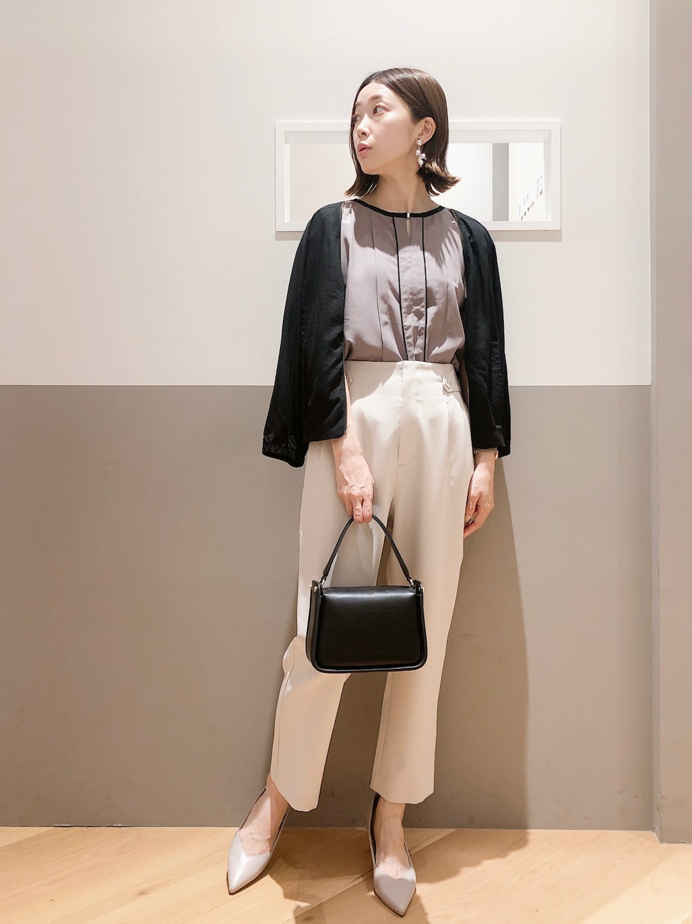 ブラウン系のシャツ/ブラウス、ブラック系のブルゾン、ベージュ系のスラックスを着用したレディースの夏コーディネートの1枚目の写真