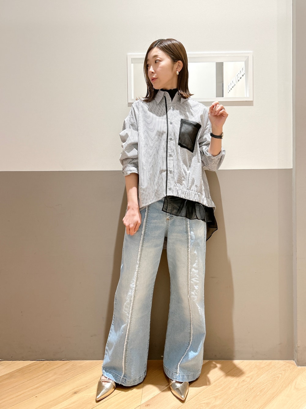 ブラック系のシャツ/ブラウス、ブラック系のTシャツ/カットソー、ブルー系のデニムパンツを着用したレディースの春コーディネートの1枚目の写真