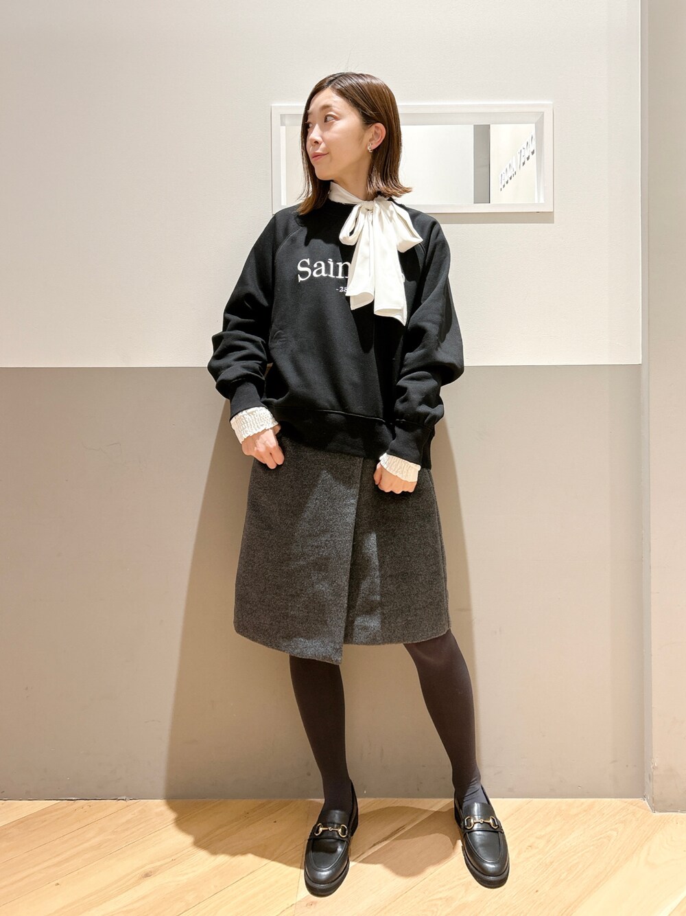 ブラック系のスウェット、ホワイト系のシャツ/ブラウス、グレー系のスカートを着用したレディースの冬コーディネートの1枚目の写真