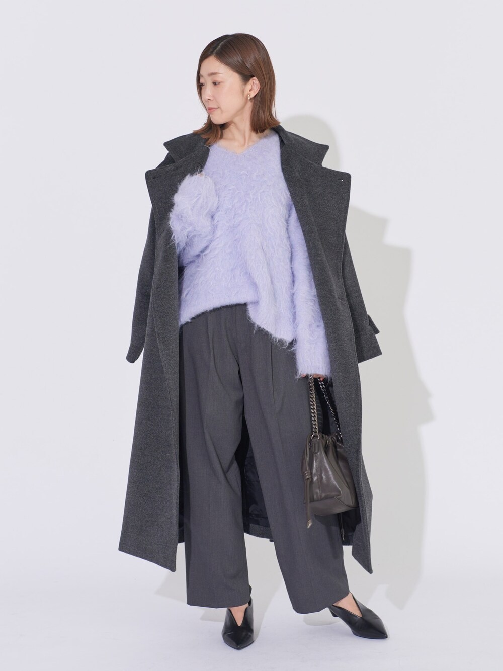 グレー系のその他アウター、パープル系のニット/セーター、グレー系のその他パンツを着用したレディースの冬コーディネートの1枚目の写真