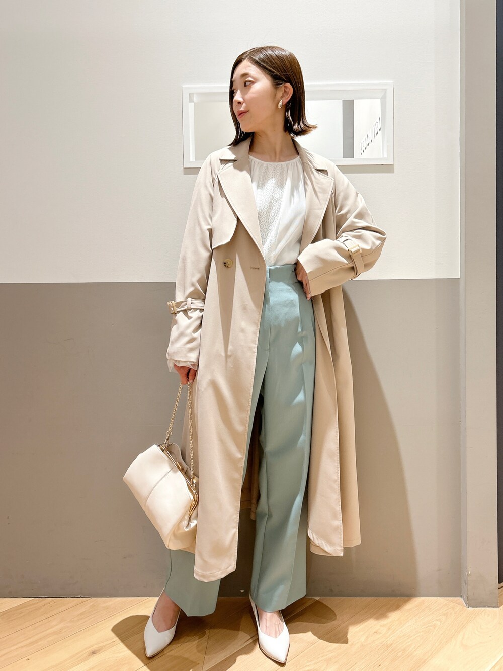 ベージュ系のトレンチコート、ホワイト系のシャツ/ブラウス、グリーン系のその他パンツを着用したレディースの春コーディネートの1枚目の写真
