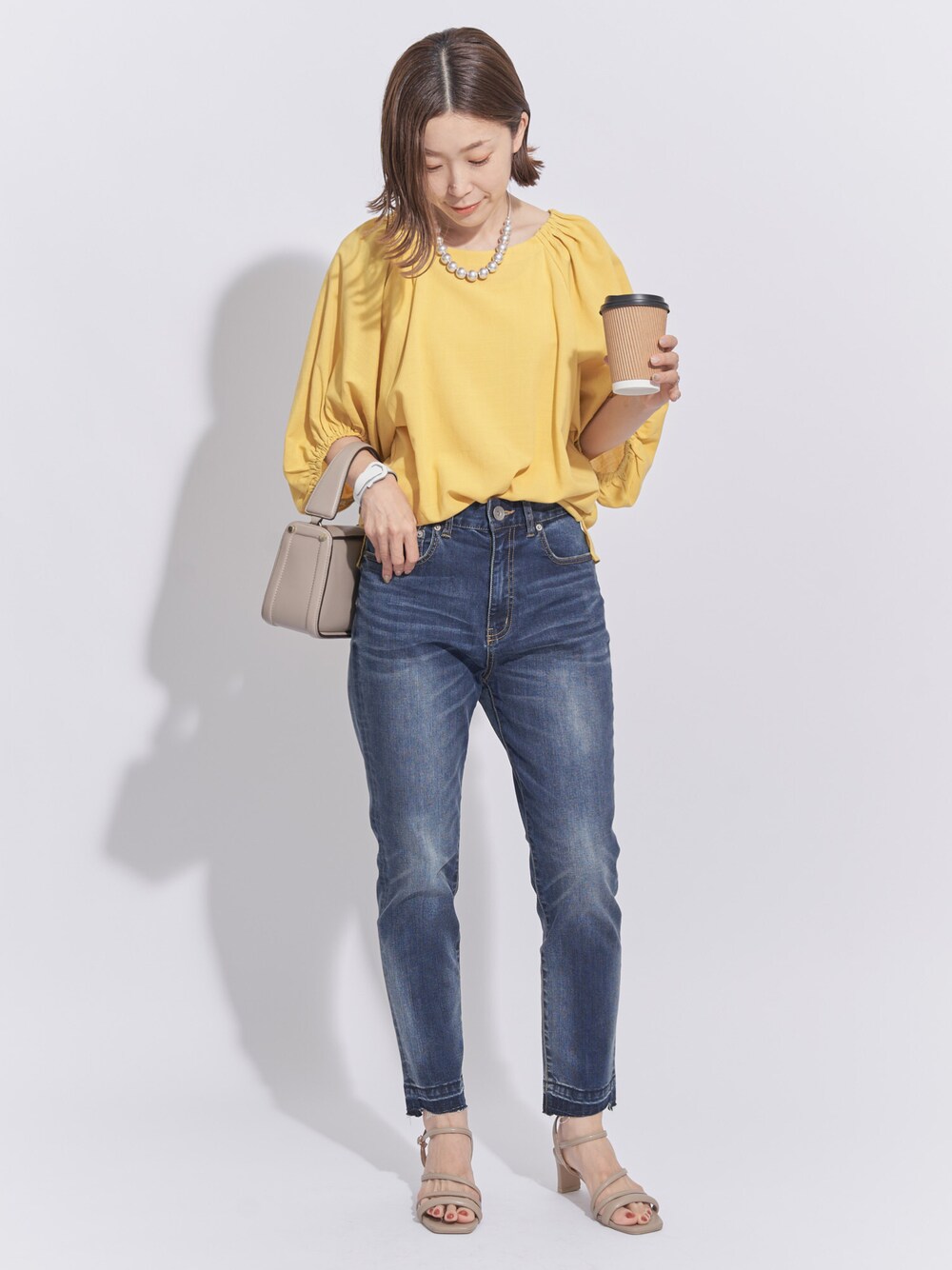 イエロー系のシャツ/ブラウス、ブルー系のパンツ、ベージュ系のサンダルを着用したレディースの夏コーディネートの1枚目の写真