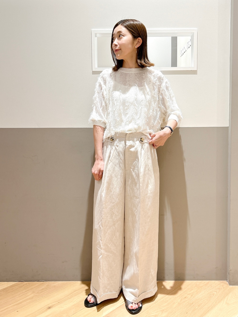 ホワイト系のニット/セーター、ベージュ系のその他パンツを着用したレディースの夏コーディネートの1枚目の写真