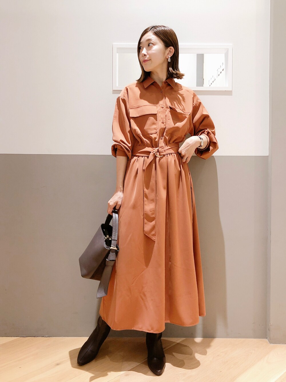 ブラウン系のワンピース、ブラウン系のシューズ、グレー系のイヤリングを着用したレディースの秋コーディネートの1枚目の写真