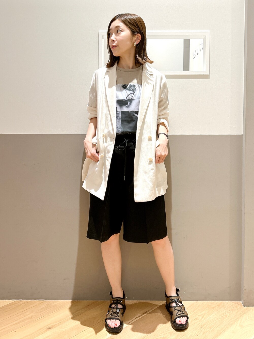 ホワイト系のテーラードジャケット、ベージュ系のTシャツ/カットソー、ブラック系のその他パンツを着用したレディースの夏コーディネートの1枚目の写真