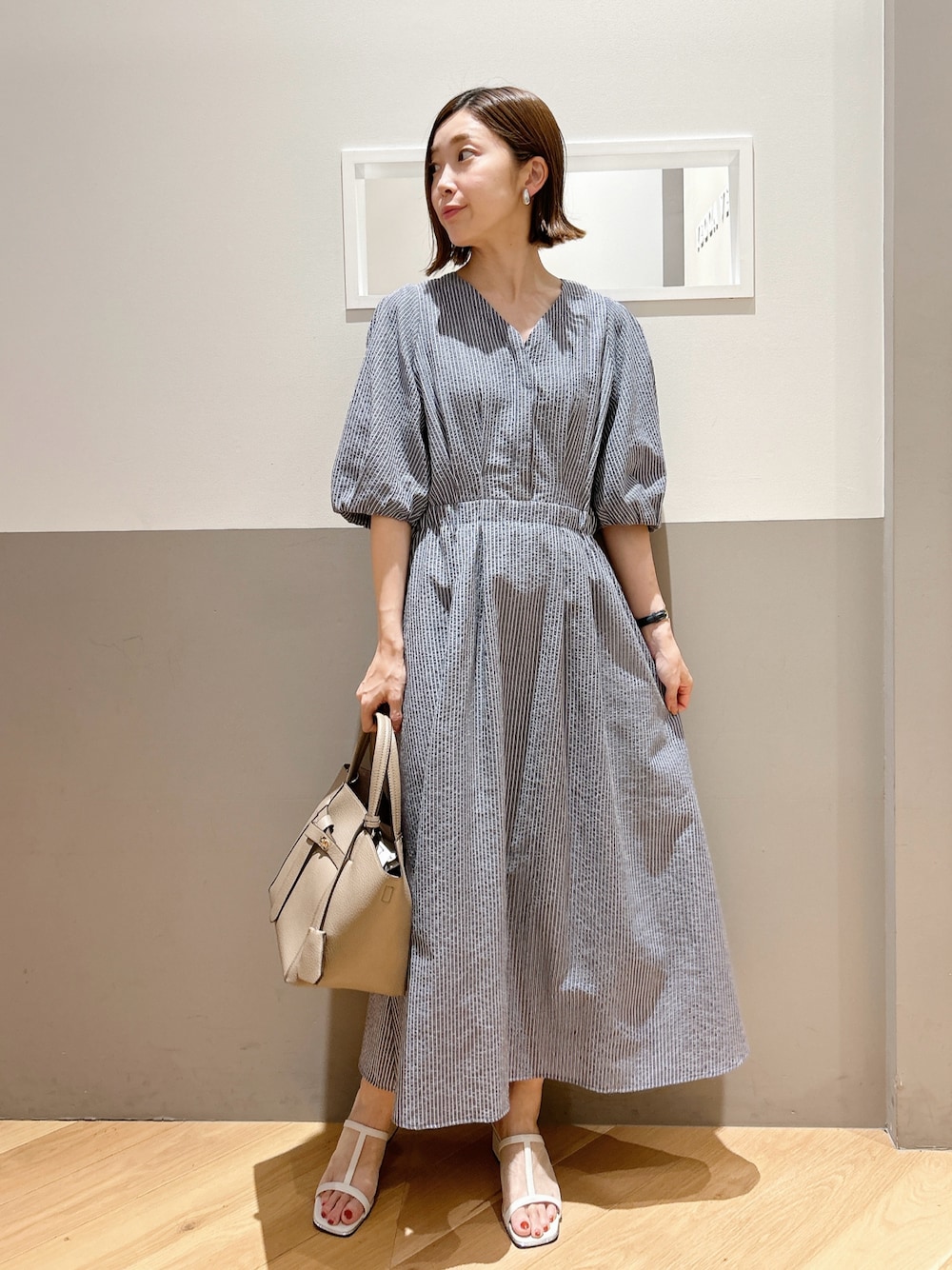 ブルー系のワンピース、ホワイト系のサンダルを着用したレディースの夏コーディネートの1枚目の写真