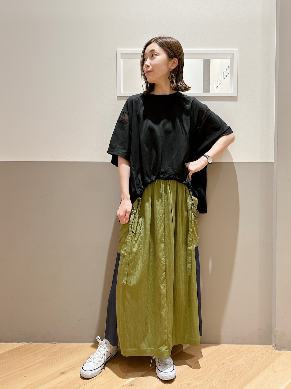 ブラック系のTシャツ/カットソー、その他のスカート、ホワイト系のスニーカーを着用したレディースの春コーディネートの1枚目の写真