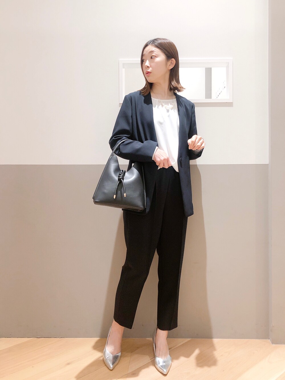 ブルー系のノーカラージャケット、ブルー系のスラックス、ホワイト系のシャツ/ブラウスを着用したレディースの冬コーディネートの1枚目の写真