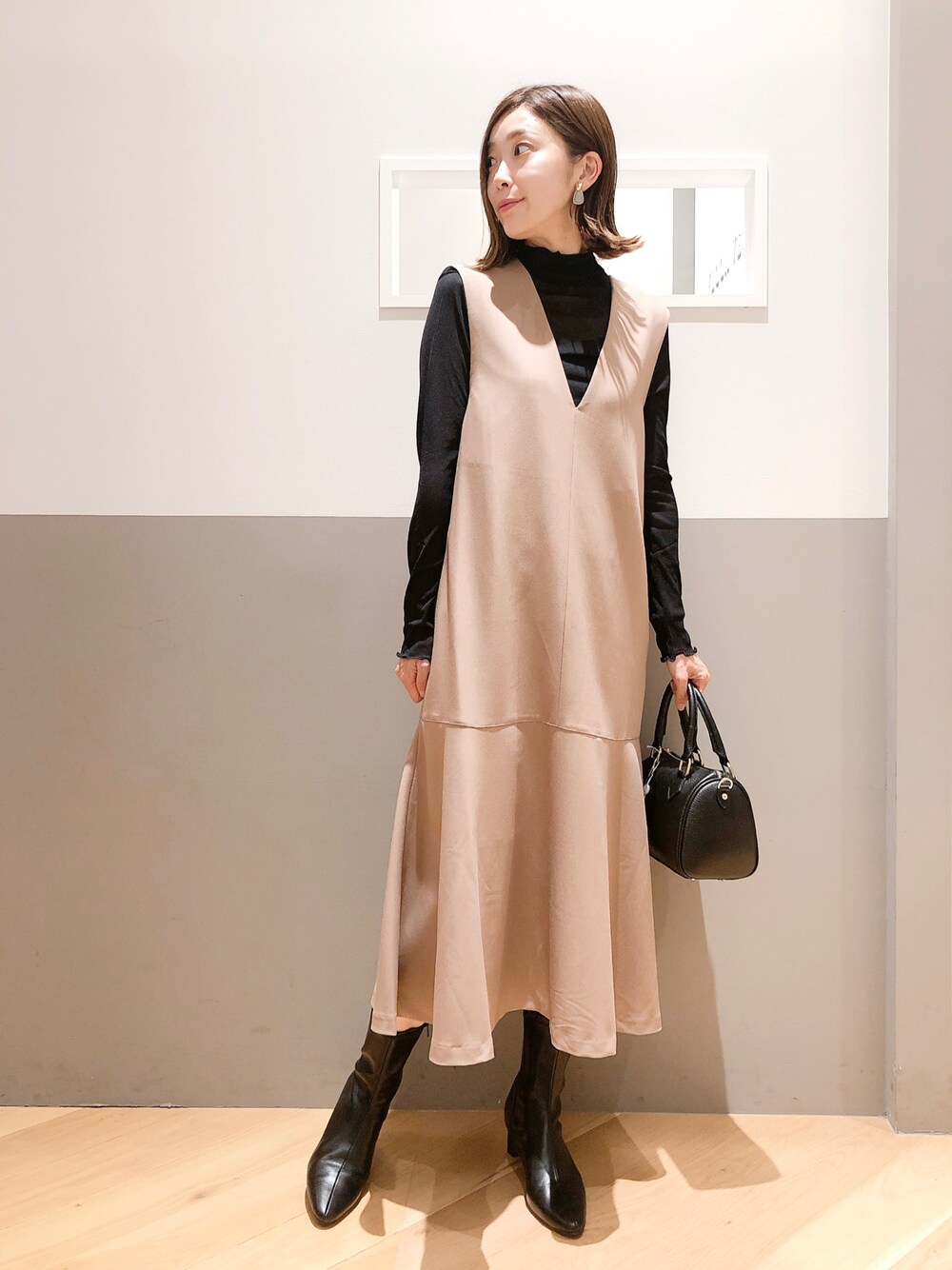 ベージュ系のワンピース、ブラック系のTシャツ/カットソー、ブラック系のシューズを着用したレディースの秋コーディネートの1枚目の写真