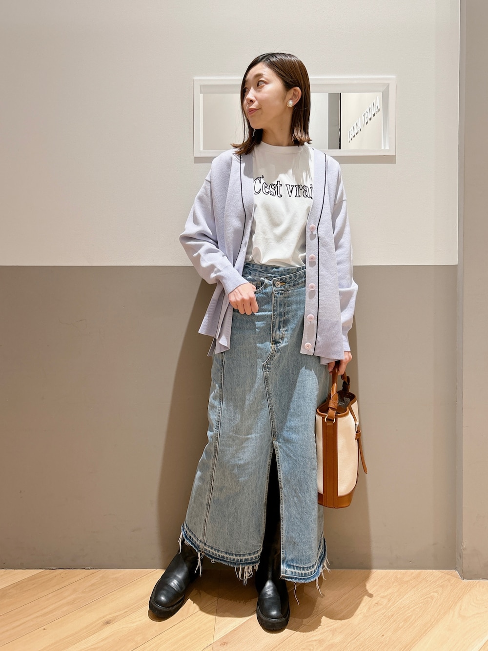 パープル系のカーディガン/ボレロ、ホワイト系のTシャツ/カットソー、ブルー系のスカートを着用したレディースの冬コーディネートの1枚目の写真