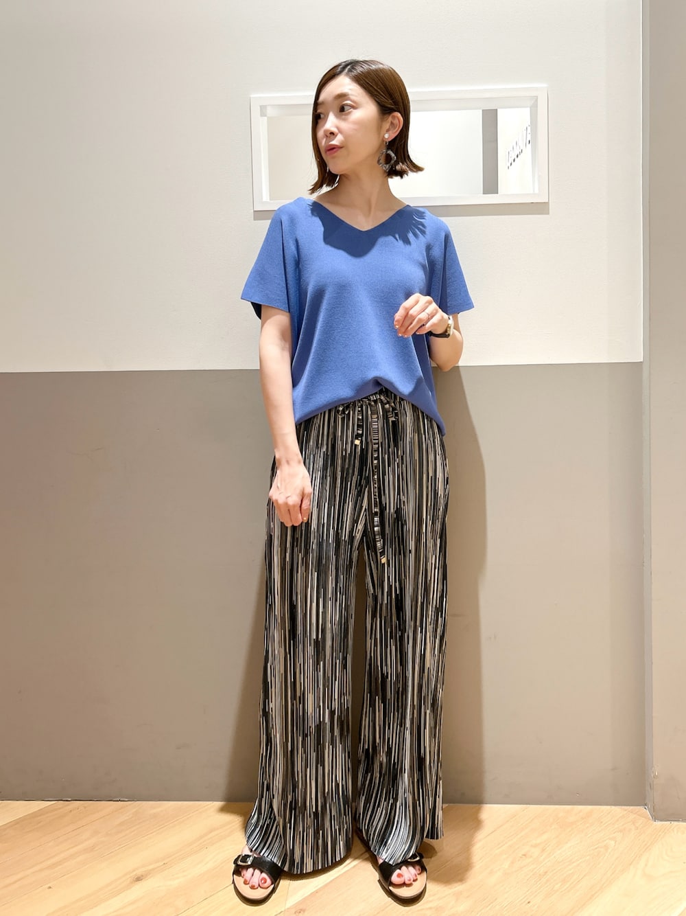 ブルー系のニット/セーター、その他のその他パンツ、グレー系のイヤリングを着用したレディースの夏コーディネートの1枚目の写真