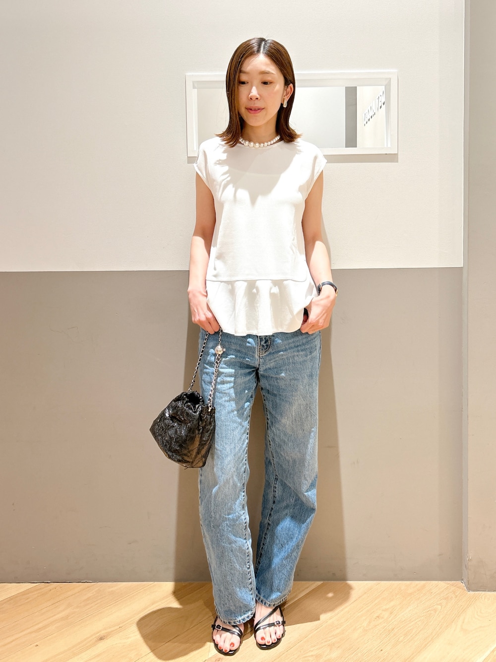 ホワイト系のシャツ/ブラウス、ブルー系のデニムパンツ、ブラック系のサンダルを着用したレディースの夏コーディネートの1枚目の写真