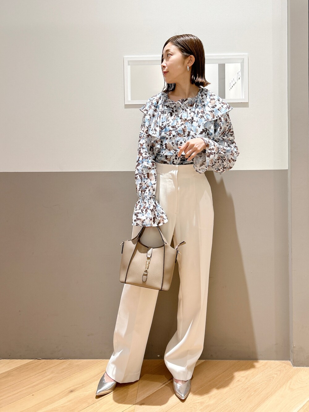 ホワイト系のシャツ/ブラウス、ホワイト系のその他パンツ、ベージュ系のエコバッグ/サブバッグを着用したレディースの春コーディネートの1枚目の写真
