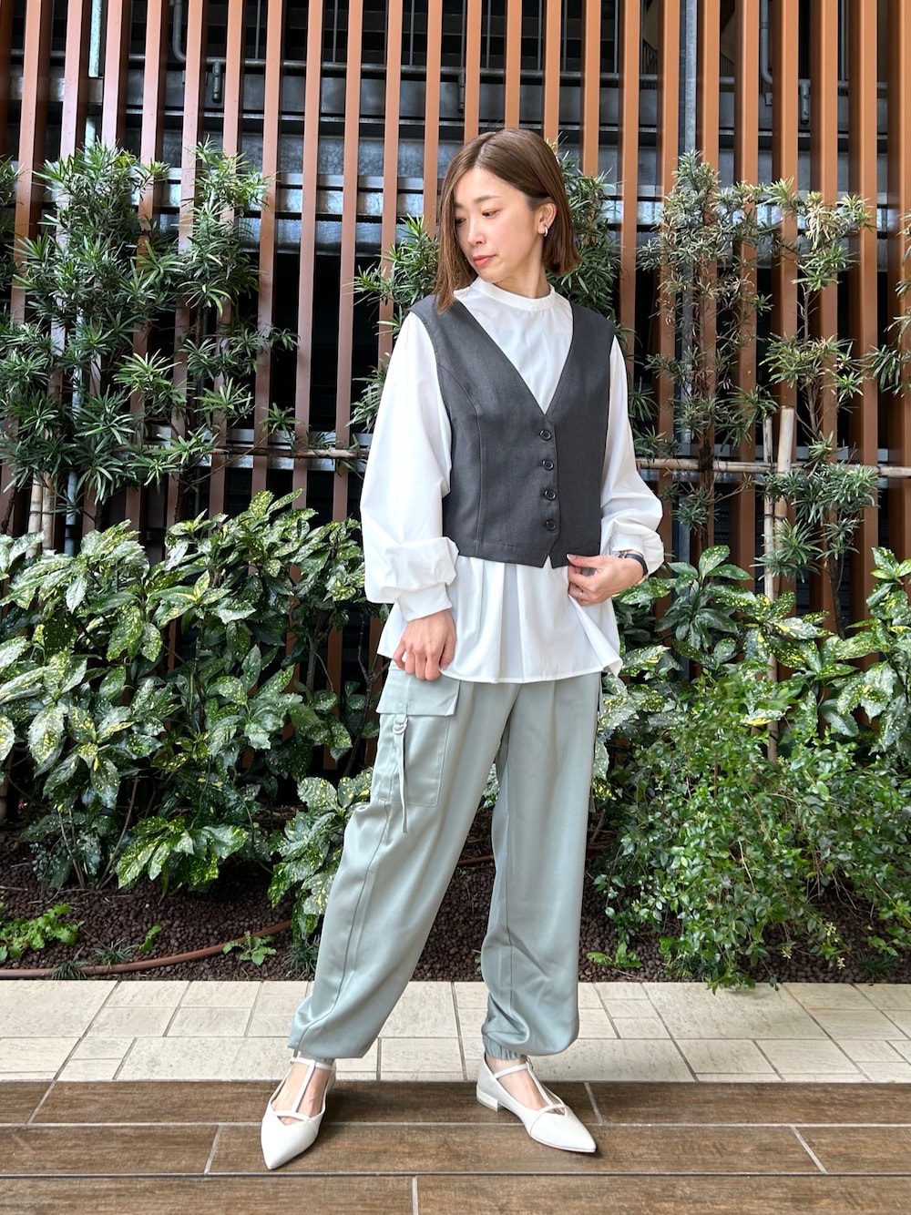 グレー系のシャツ/ブラウス、グリーン系のカーゴパンツ、ホワイト系のパンプスを着用したレディースの春コーディネートの1枚目の写真