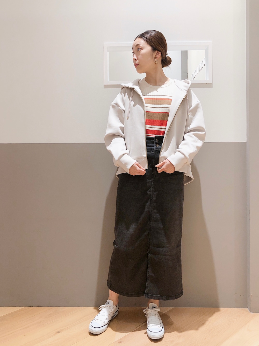 ベージュ系のパーカー、ホワイト系のニット/セーター、ブラック系のスカートを着用したレディースの秋コーディネートの1枚目の写真