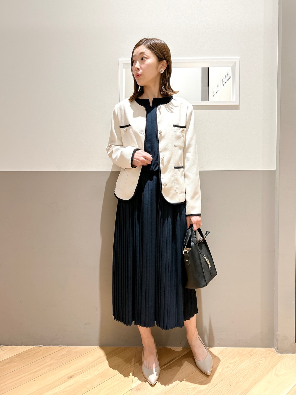 ベージュ系のその他アウター、ブルー系のワンピース、ブラック系のエコバッグ/サブバッグを着用したレディースの冬コーディネートの1枚目の写真