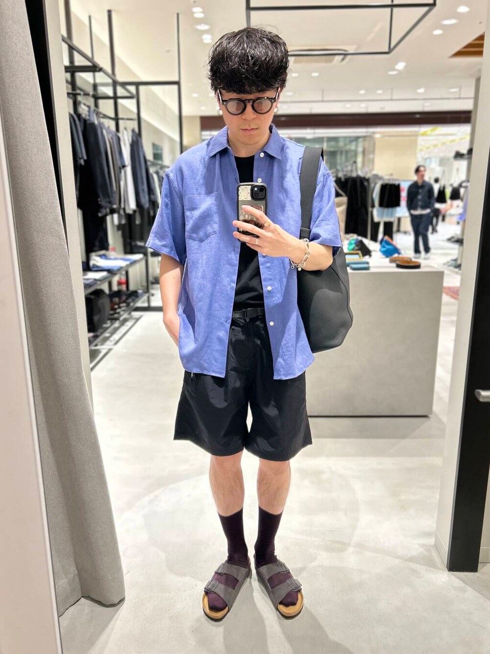 ブラック系のその他パンツ、グレー系のサンダル、ブラック系のトートバッグを着用したメンズの春コーディネートの1枚目の写真