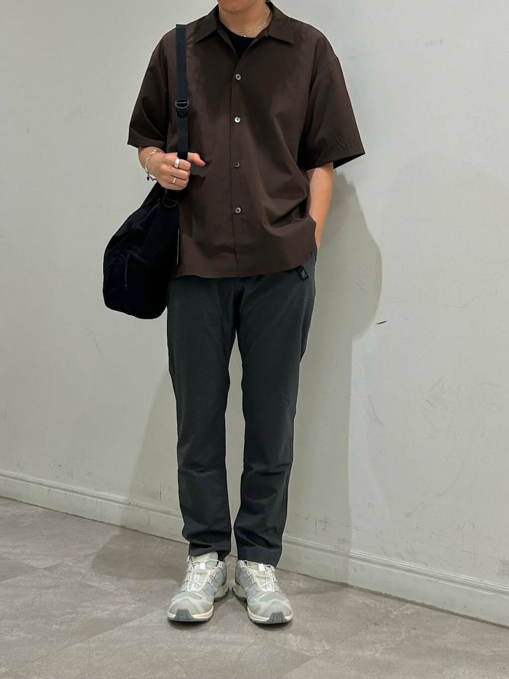 ブラック系のショルダーバッグ、グレー系のその他パンツ、ホワイト系のスニーカーを着用したメンズの夏コーディネートの1枚目の写真