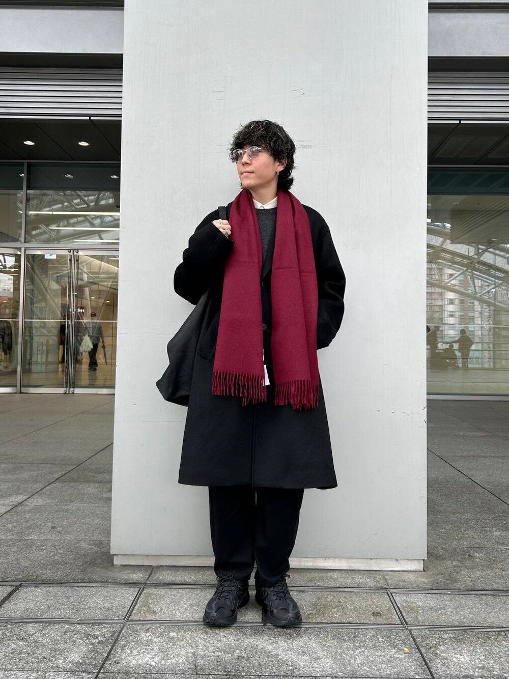 ブラック系のチェスターコート、ホワイト系のシャツ/ブラウス、グレー系のニット/セーターを着用したメンズの秋コーディネートの1枚目の写真