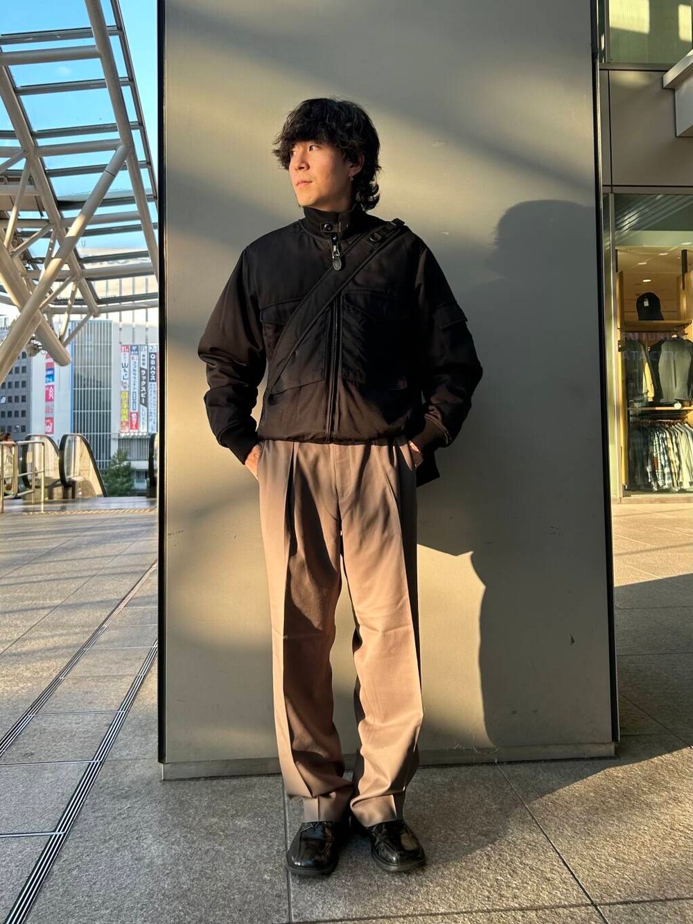 ブラック系のトートバッグ、ベージュ系のその他パンツ、ブラック系のその他アウターを着用したメンズの秋コーディネートの1枚目の写真