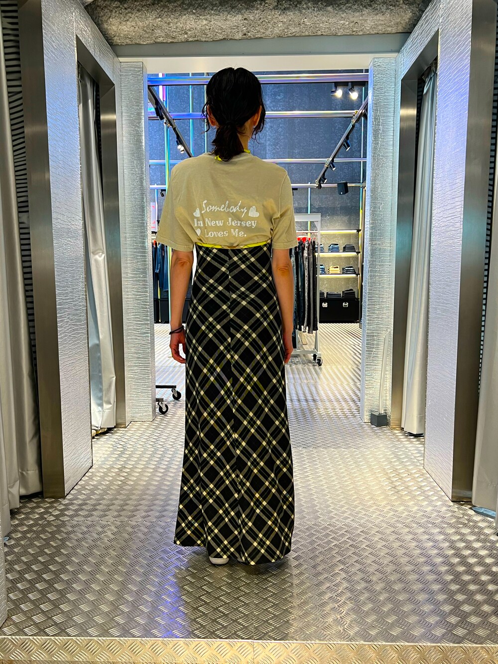 ブラック系のワンピース、ベージュ系のTシャツ/カットソー、ホワイト系のスニーカーを着用したレディースの春コーディネートの1枚目の写真