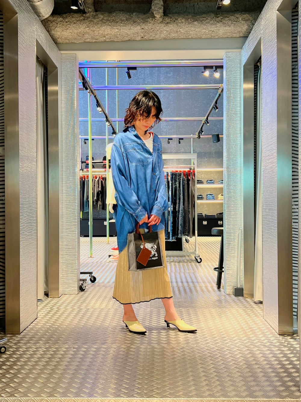 ブルー系のワンピース、ベージュ系のワンピース、ブラック系のトートバッグを着用したレディースの春コーディネートの1枚目の写真