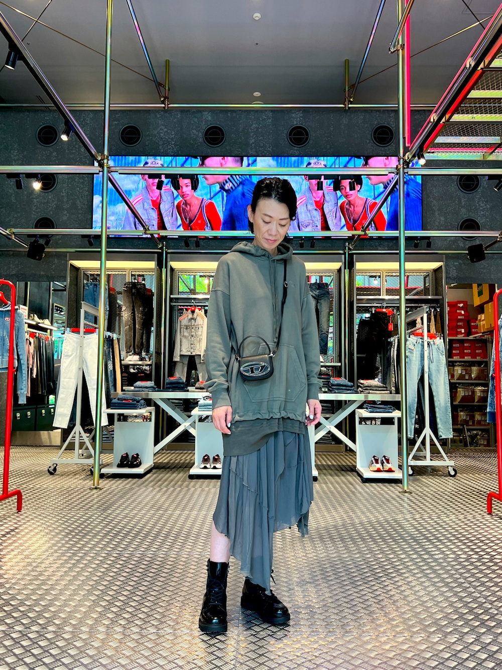 グリーン系のワンピース、ブラック系のショルダーバッグを着用したレディースの秋コーディネートの1枚目の写真