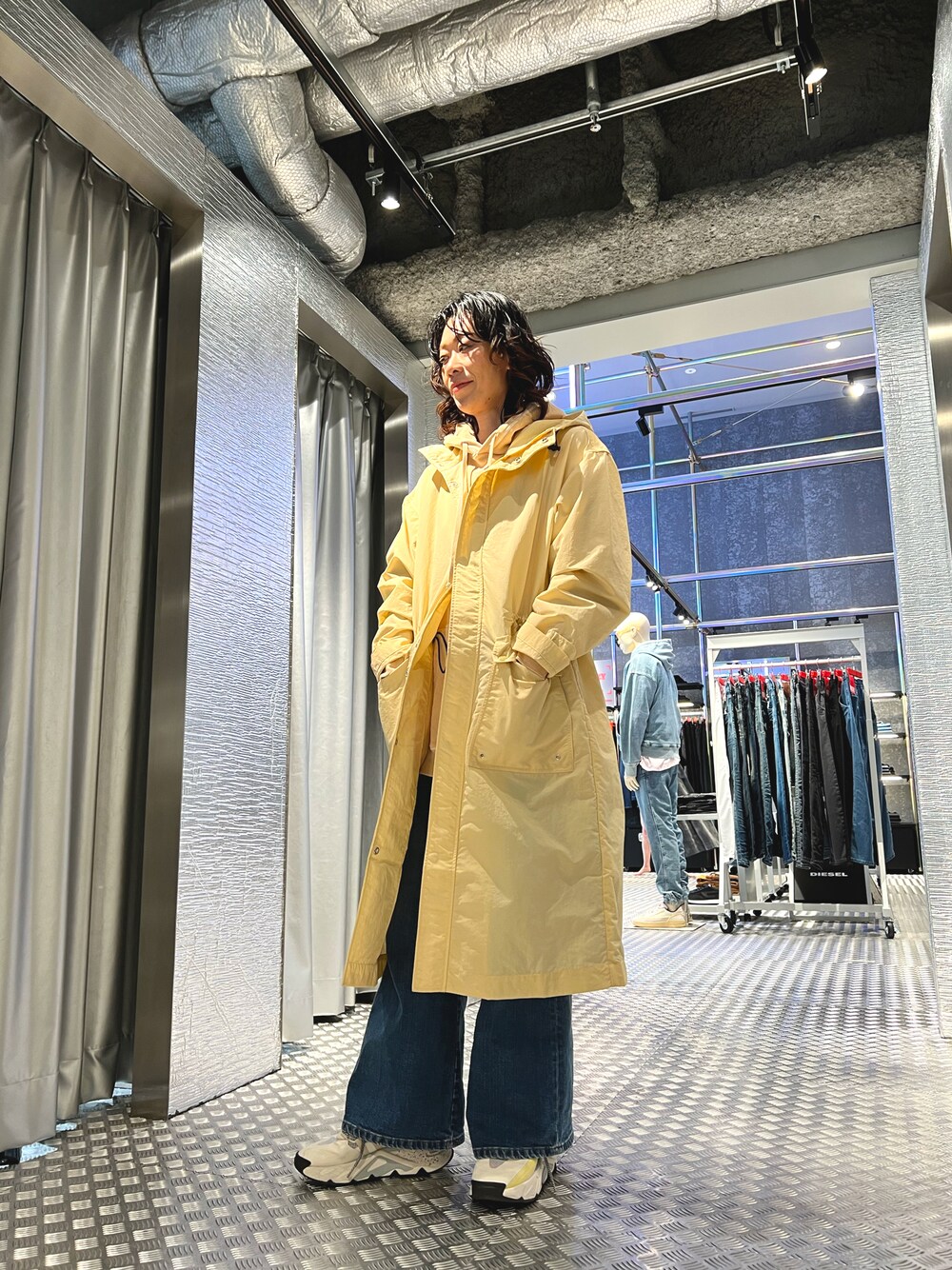 ベージュ系のモッズコート、ベージュ系のスウェット、ブルー系のデニムパンツを着用したレディースの冬コーディネートの1枚目の写真