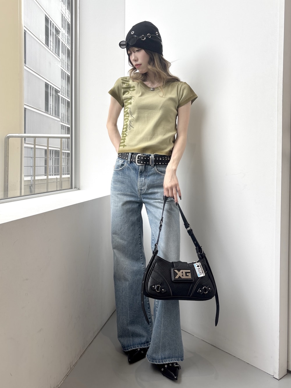 グリーン系のTシャツ/カットソー、ブルー系のデニムパンツ、ピンク系のショルダーバッグを着用したレディースの春コーディネートの1枚目の写真