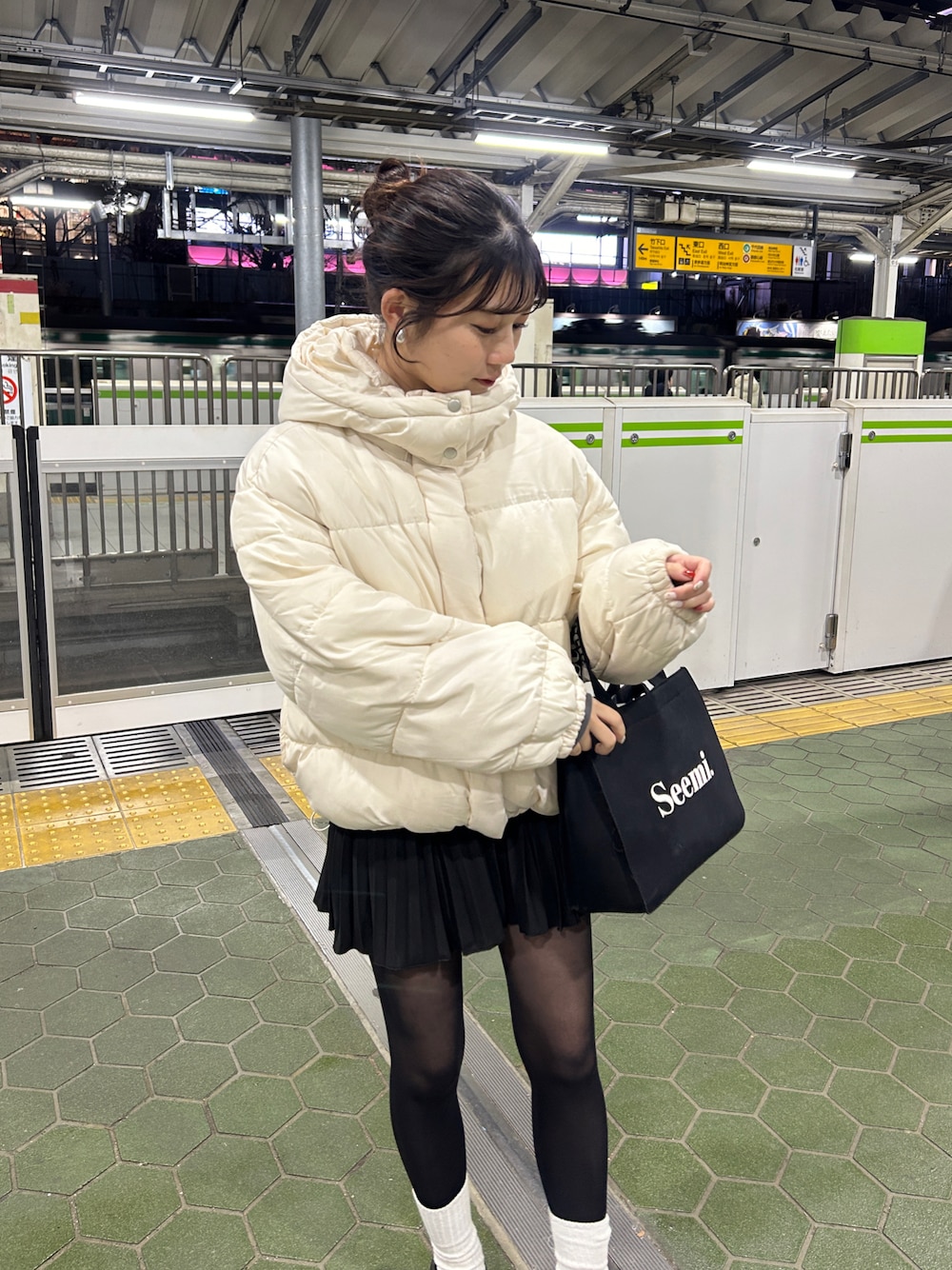 ホワイト系のダウンジャケット/コート、ブラック系のスカートを着用したレディースの冬コーディネートの1枚目の写真