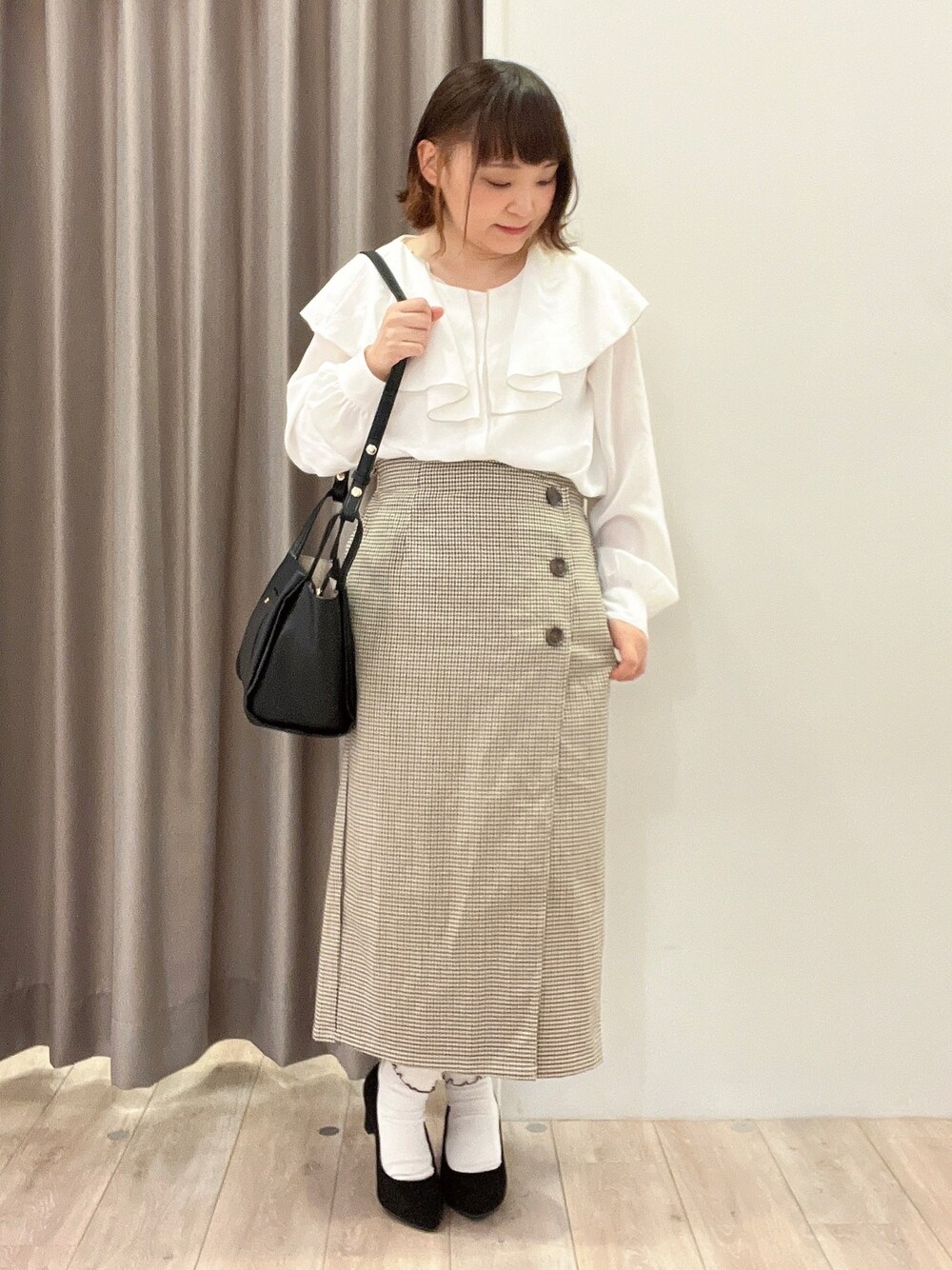 ホワイト系のシャツ/ブラウス、ベージュ系のスカート、ブラック系のパンプスを着用したレディースの秋コーディネートの1枚目の写真