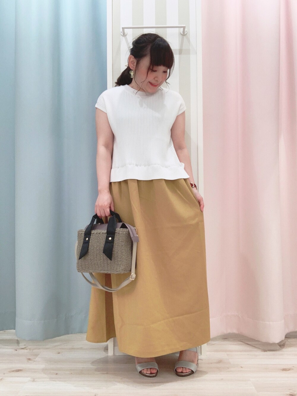 グレー系のショルダーバッグ、シルバー系のサンダル、イエロー系のワンピースを着用したレディースの春コーディネートの1枚目の写真