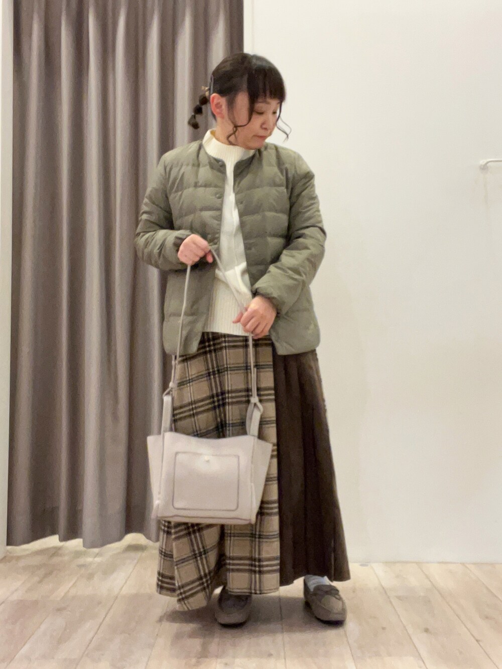 グリーン系のダウンジャケット/コート、ブルー系のスカート、ベージュ系のその他シューズを着用したレディースの冬コーディネートの1枚目の写真