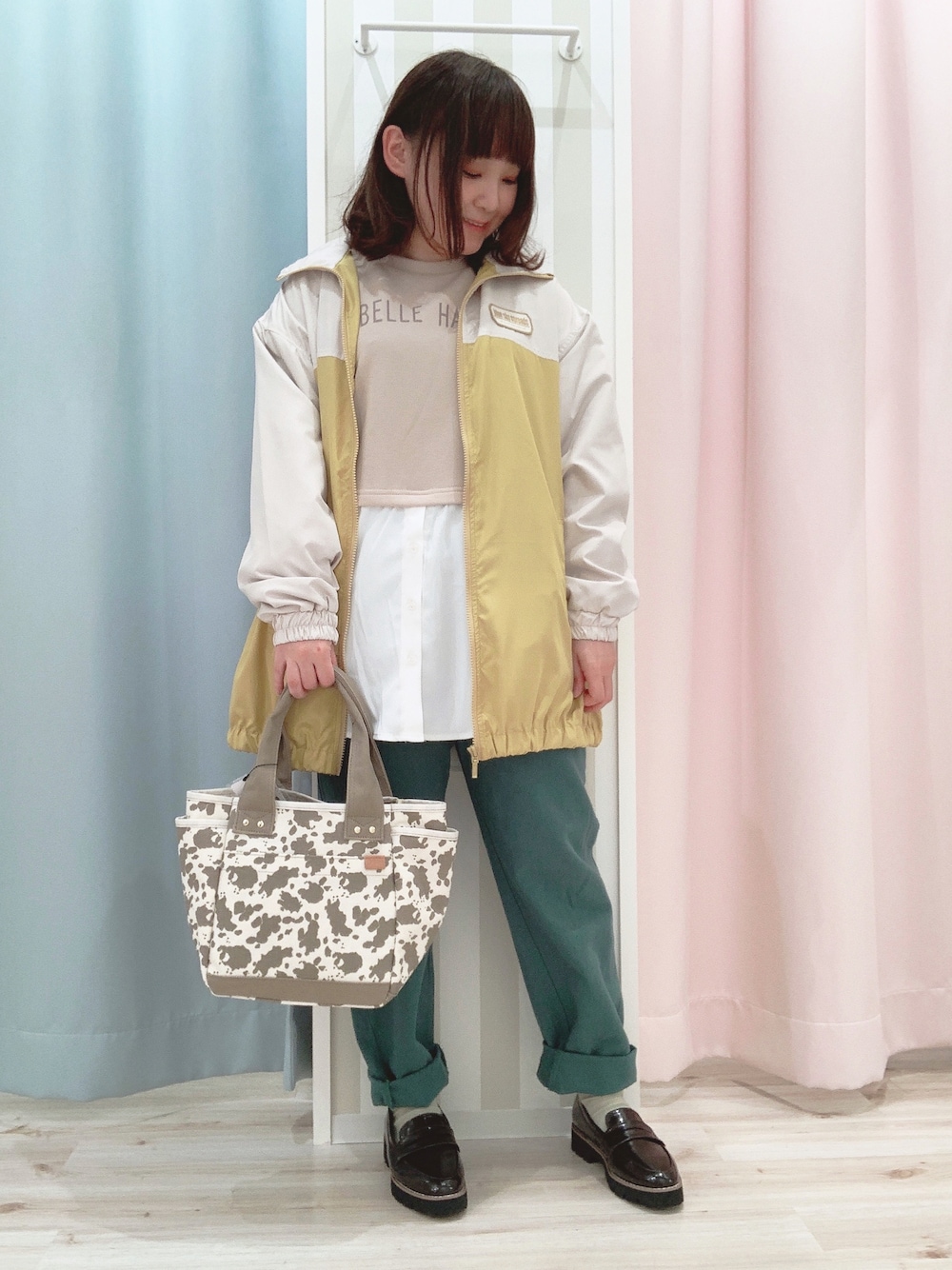 ベージュ系のスウェット、イエロー系のブルゾン、グリーン系のデニムパンツを着用したレディースの春コーディネートの1枚目の写真