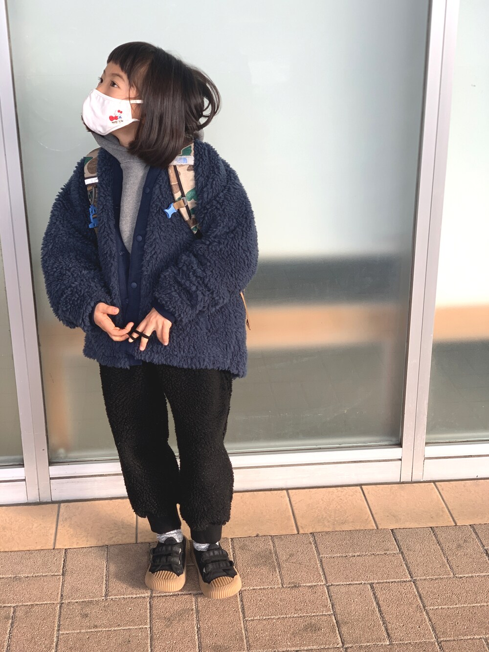 ブルー系のブルゾン、ブラック系のパンツ、ブラック系のスニーカーを着用したキッズの冬コーディネートの1枚目の写真