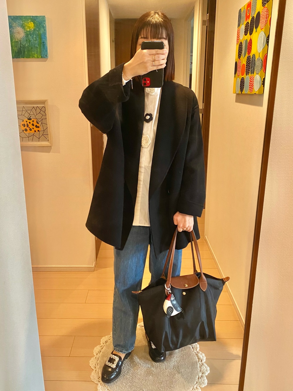 ブラック系のジャケット/アウター、ホワイト系のトップス、ブルー系のデニムパンツを着用したレディースの秋コーディネートの1枚目の写真