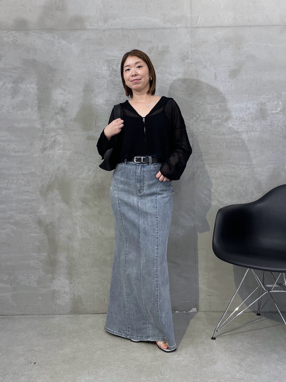 ブラック系のカーディガン/ボレロ、ブルー系のスカート、ブラック系のショルダーバッグを着用したレディースの夏コーディネートの1枚目の写真
