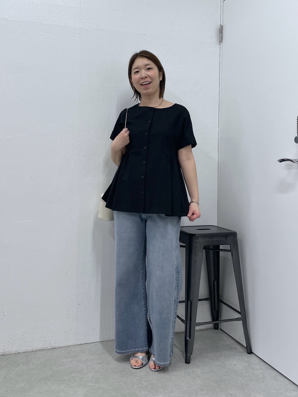 ブラック系のシャツ/ブラウス、ブルー系のデニムパンツ、ホワイト系のショルダーバッグを着用したレディースの春コーディネートの1枚目の写真