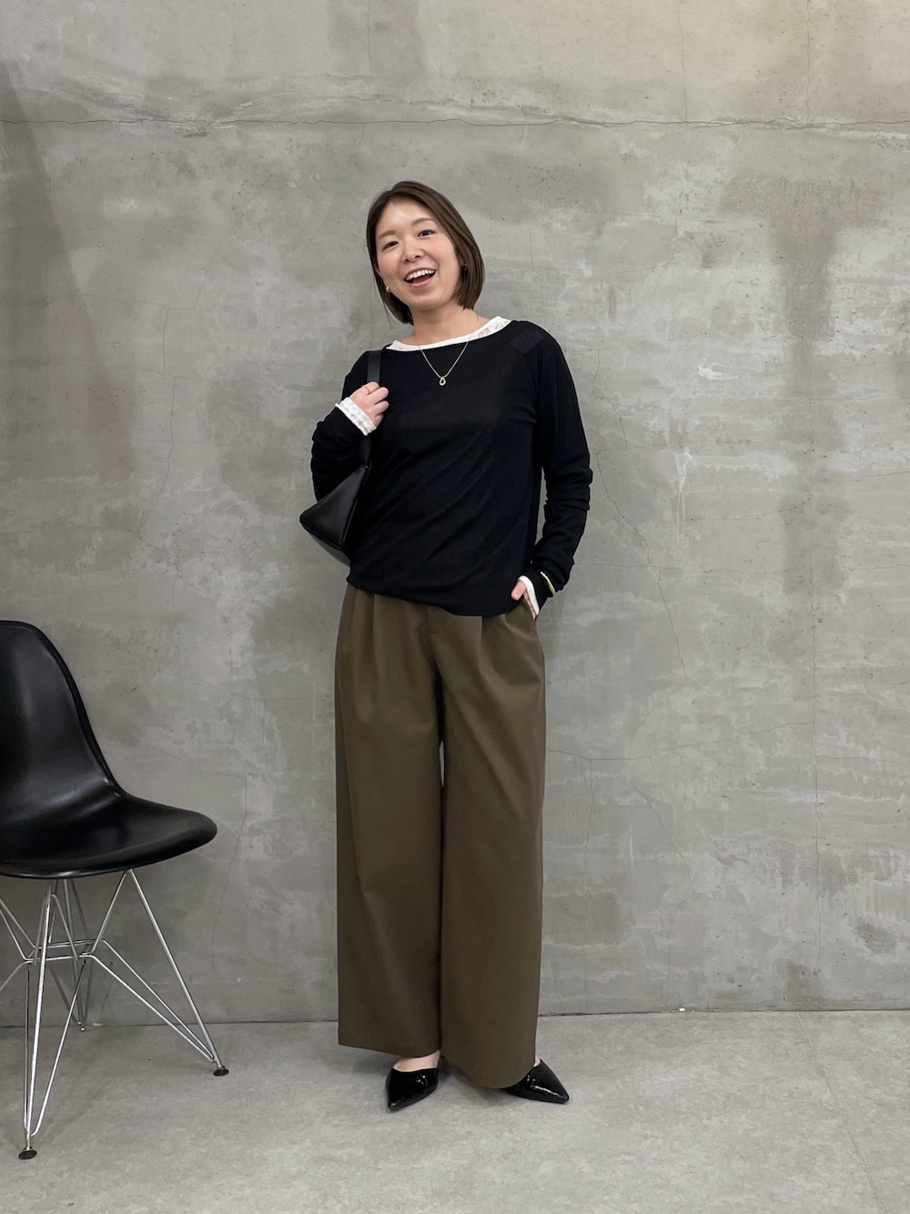 グリーン系のチノパンツ、ブラック系のTシャツ/カットソー、ホワイト系のTシャツ/カットソーを着用したレディースの冬コーディネートの1枚目の写真