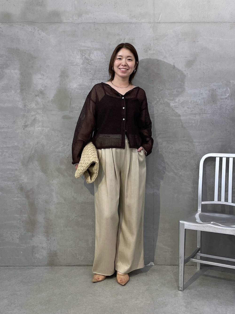 ブラウン系のニット/セーター、ベージュ系のその他パンツ、ホワイト系のトートバッグを着用したレディースの夏コーディネートの1枚目の写真