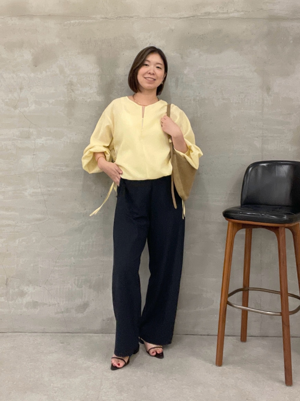 ブラック系のその他パンツ、ベージュ系のショルダーバッグ、イエロー系のシャツ/ブラウスを着用したレディースの夏コーディネートの1枚目の写真