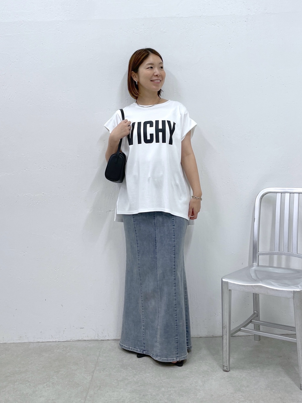 ホワイト系のTシャツ/カットソー、ブルー系のスカート、ブラック系のショルダーバッグを着用したレディースの夏コーディネートの1枚目の写真