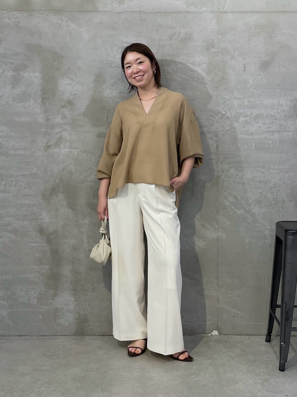 ベージュ系のシャツ/ブラウス、ホワイト系のスラックス、ホワイト系のショルダーバッグを着用したレディースの春コーディネートの1枚目の写真